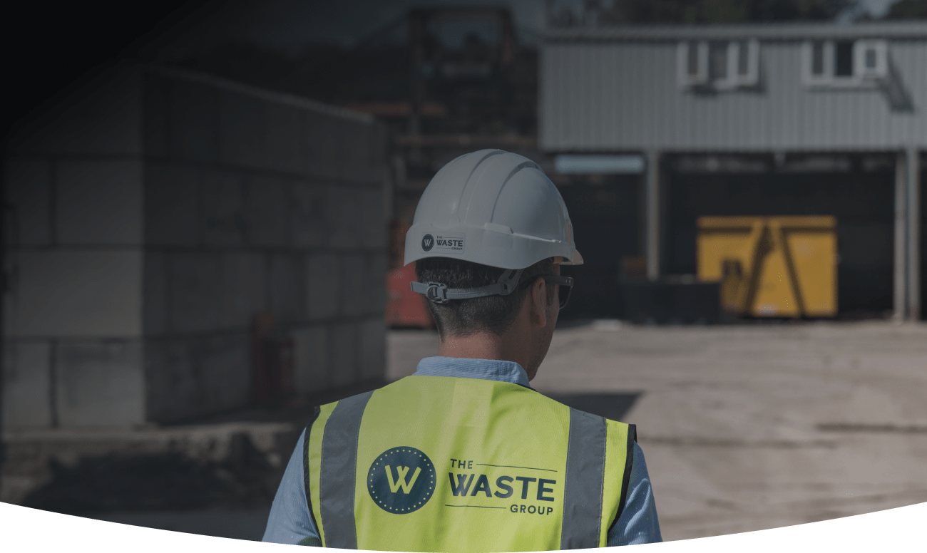 a man wearing a vest with the waste group logo on his back